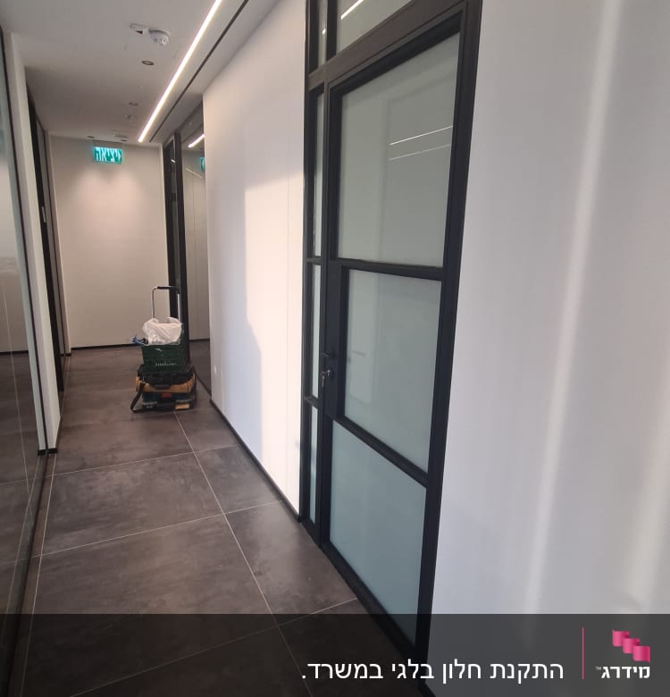 דלת אלומיניום עם מסגרת שחורה במסדרון משרדי